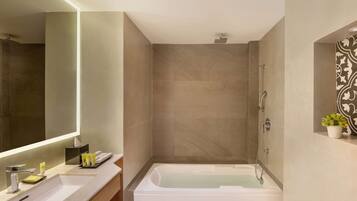 A modern bathroom with a large mirror, a bathtub, and a shower.