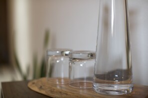 Trois vases en verre transparent, posés sur un plateau en bois.