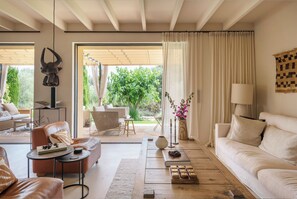 Ein modernes Wohnzimmer mit Sofa, Couchtisch und Blick auf den Garten.