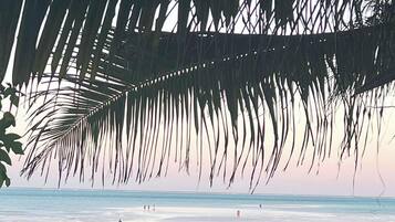 On the beach, white sand, sun-loungers, beach umbrellas