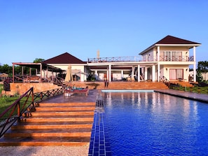 A two-story building with a swimming pool, outdoor seating, and a covered patio area. - The Villa of Zanzibar (Kidoti)
