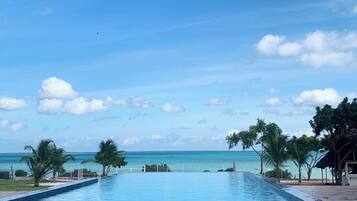 Una piscina al aire libre, sombrillas, tumbonas