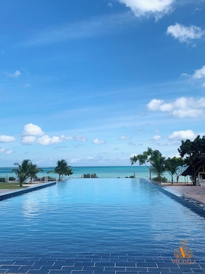 A long swimming pool with a view of the ocean and clear blue sky. - The Villa of Zanzibar (Kidoti)