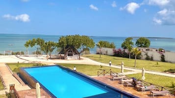 Een buitenzwembad, parasols voor strand/zwembad