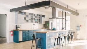 Een moderne keuken met een centraal eiland, barstoelen en een waterdispenser.