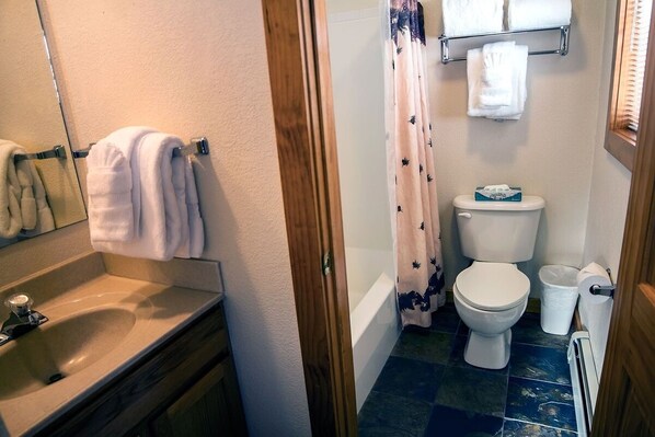 Un baño con lavamanos, inodoro y cortina de ducha.