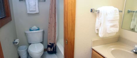 A bathroom with a toilet, a sink, and a shower curtain.