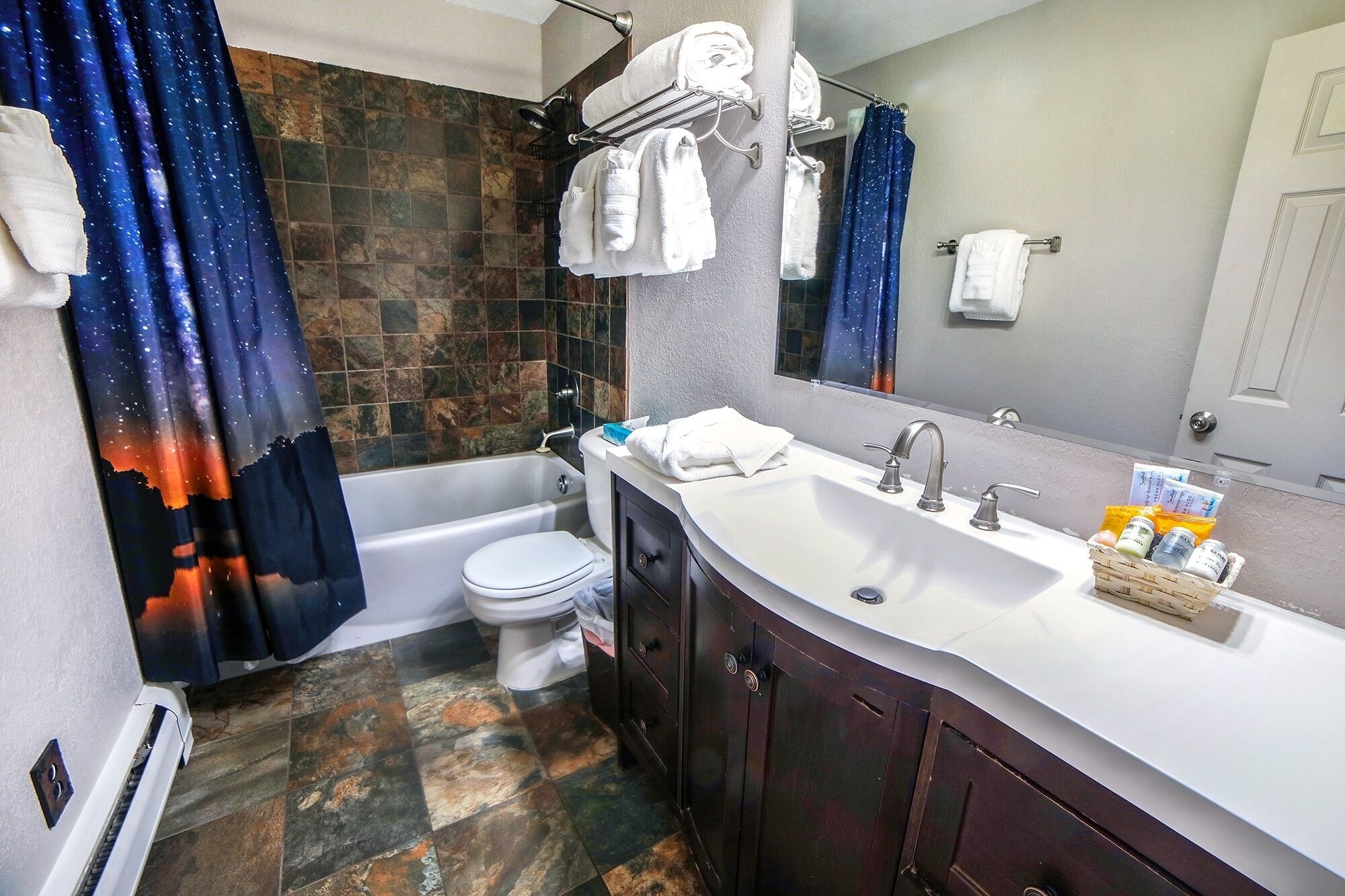 A bathroom with a bathtub, toilet, and sink.