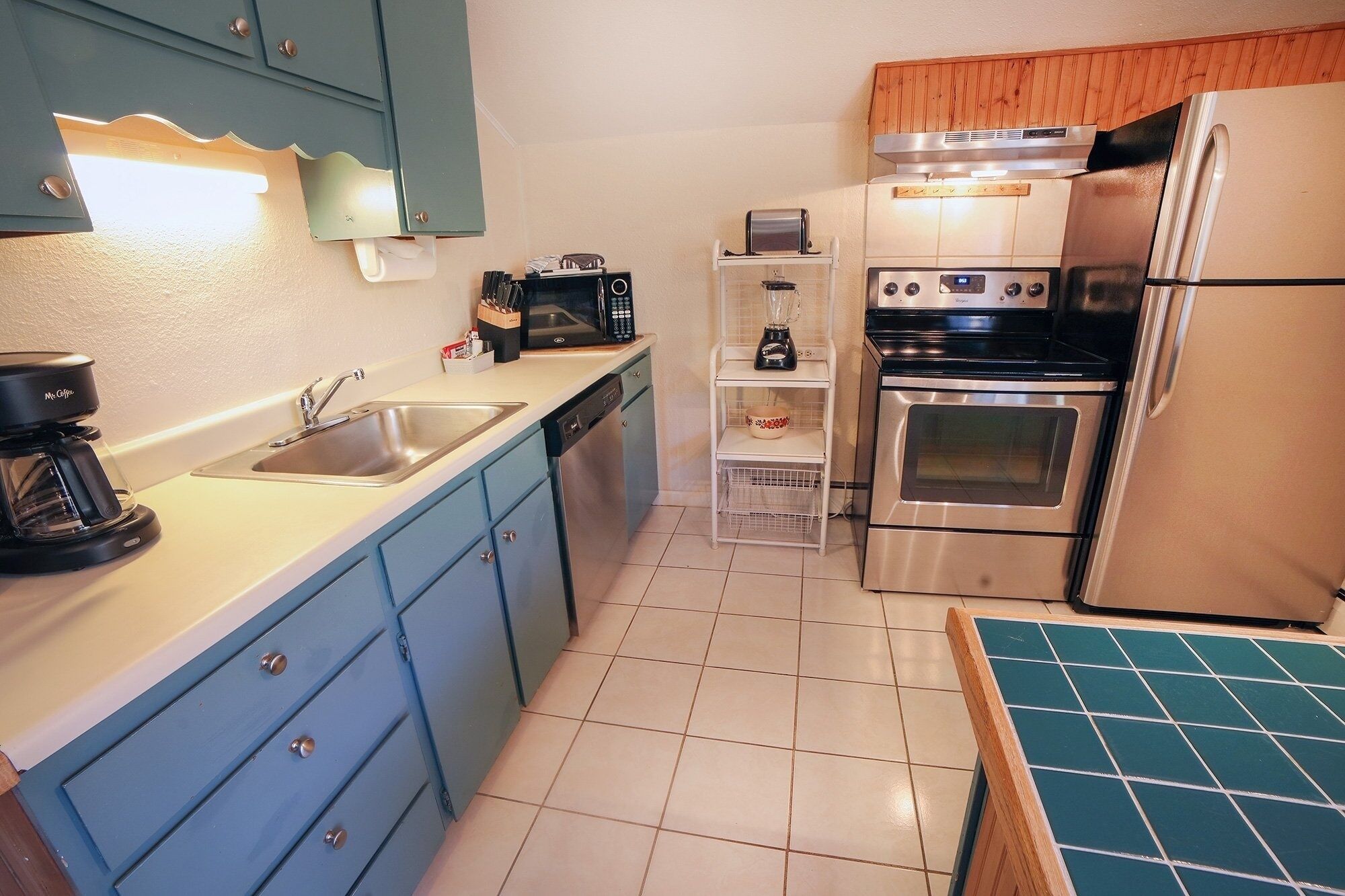 A compact kitchen with a coffee maker, toaster, and a refrigerator.