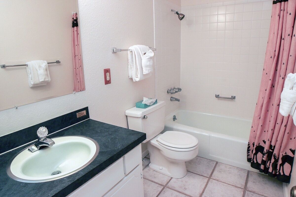 A bathroom with a sink, toilet, and bathtub.