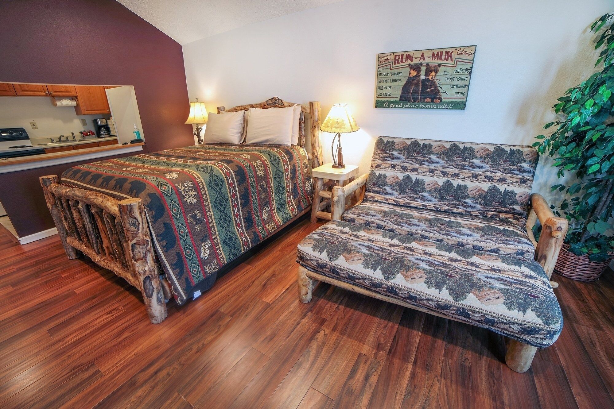 Una stanza accogliente con un letto di legno, una poltrona con motivi decorativi e un tavolino con una lampada.