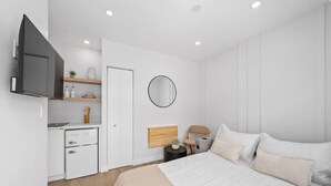 Un dormitorio moderno con cama, mesita de noche y televisión integrada.