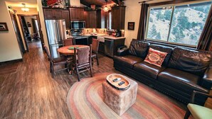 Ein gemütliches Wohnzimmer mit Ledersofa, einem Holzesstisch und einem Kamin.