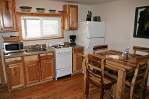 Enjoy cooking in this well-equipped kitchen with a central island, microwave, stove, sink, and refrigerator.