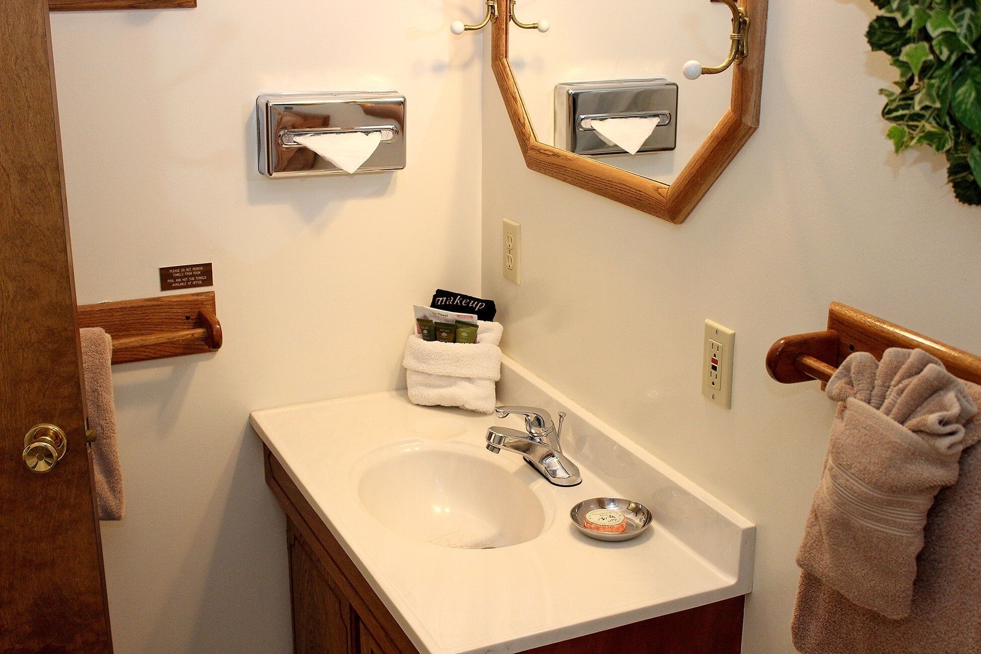 Une salle de bain équipée d’un lavabo, d’un miroir, d’un porte-serviettes et d’un panneau indiquant qu’il est interdit d’emporter les serviettes.