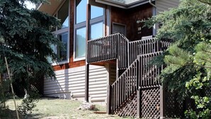 A two-story house with a wooden deck and a metal staircase. - Sunnyside Knoll: 18 1 Bedroom Cabin (Estes Park)