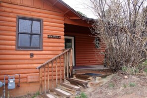 A log cabin with a wooden staircase leading to a door marked "BLUE SPRUCE B". - Lazy R Cottages: 7b 1 Bedroom Cottage (Estes Park)