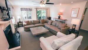A living room with a sectional sofa, a coffee table, a fireplace, and a ceiling fan. - Fawn Valley Inn: 276 2 Bedroom Condo (Estes Park)