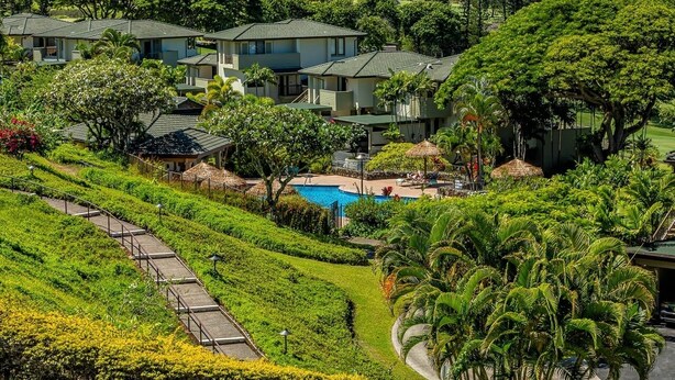 Een resort met meerdere gebouwen, een zwembad en weelderige begroeiing.