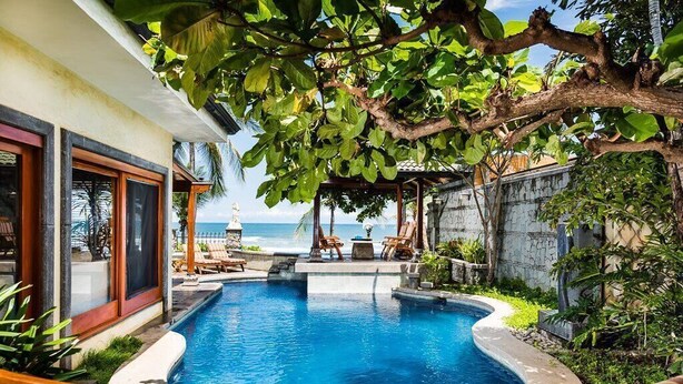 Ein privater Pool mit Liegestühlen, einer Steinmauer und Meerblick.