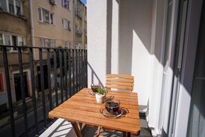 A wooden table with two cups and a small plant on a balcony. - Merkuri Apart (Istanbul)