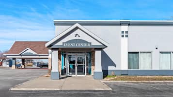 An EVENT CENTER building with a modern design, featuring a prominent entrance with glass doors and a sign above.