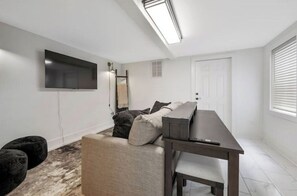 Cozy living space with a flat-screen TV, sofa, and table.