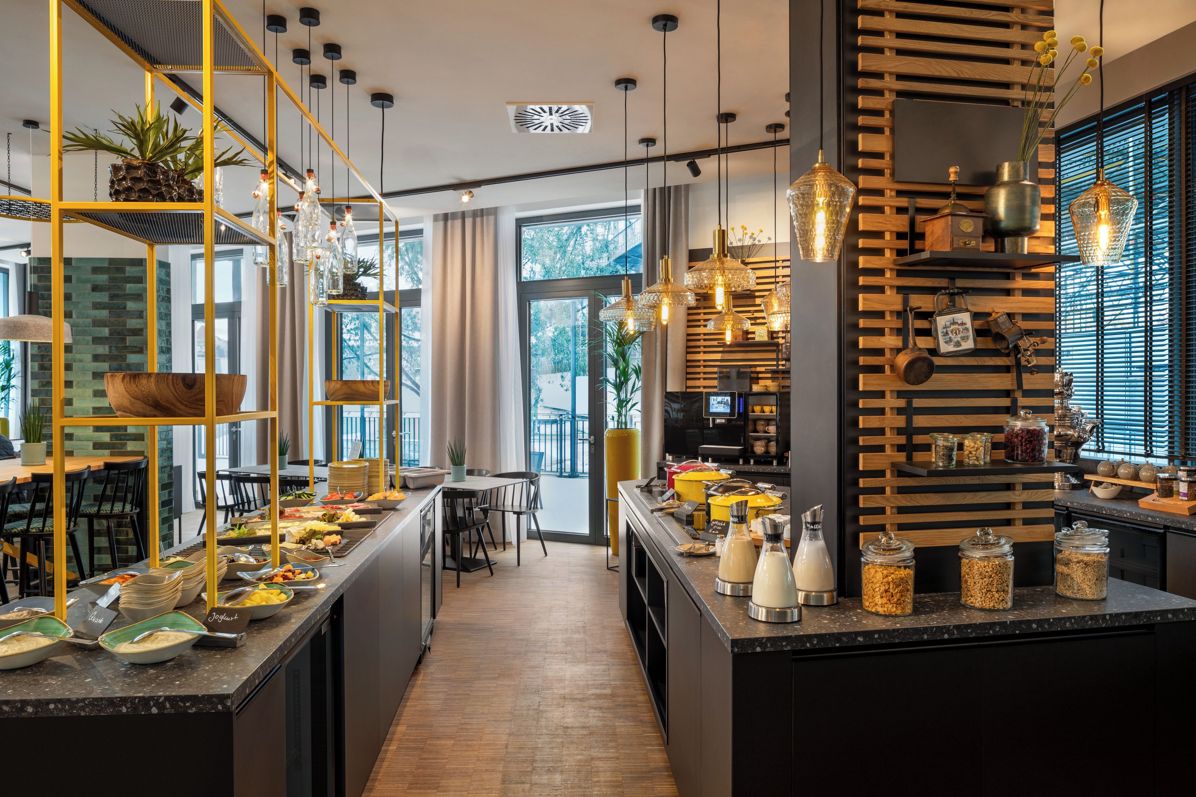 Une cuisine moderne dotée d’un îlot central, d’étagères ouvertes et de luminaires suspendus.