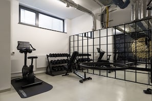 A gym with exercise equipment, a window, and ductwork on the ceiling. - Vienna House Easy Wyndham Berlin Potsdamer Platz (Berlin)