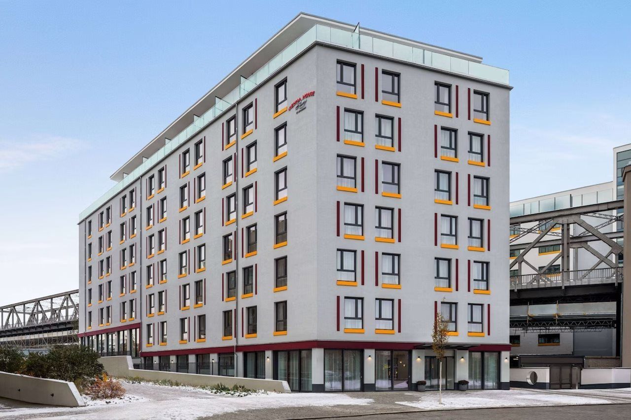 Monikerroksinen hotelli, jossa on moderni muotoilu, tasakatto ja jokaisessa kerroksessa on useita ikkunoita.