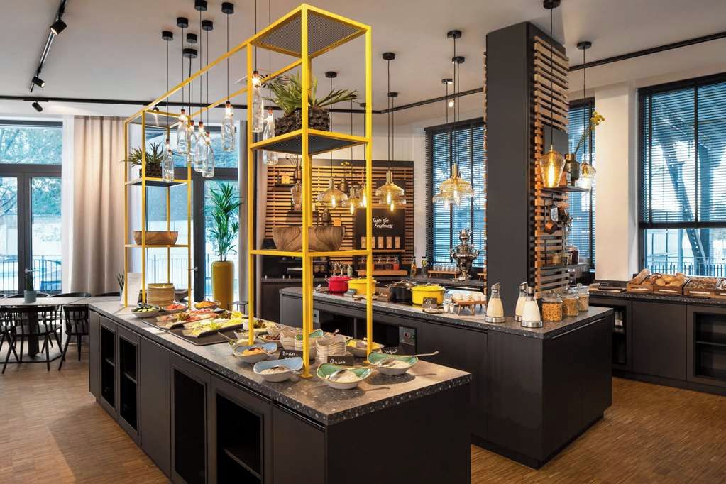 A modern kitchen with a central island, yellow shelving, and various kitchen appliances.