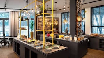 A modern kitchen with a central island, yellow shelving, and various kitchen appliances.
