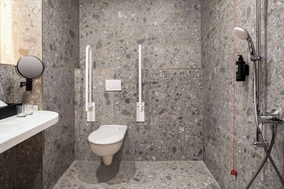 A modern bathroom with a toilet, bidet, and shower.
