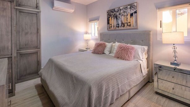 Un dormitorio con una cama grande, una mesita de noche, un tocador y un armario.