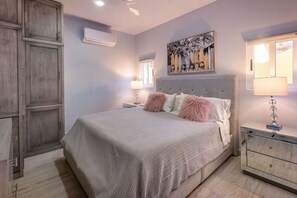 Una camera da letto con un letto grande, un comodino, una cassettiera e un armadio.