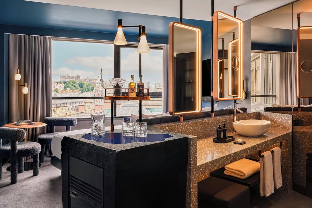 A modern bathroom with a large mirror, a sink, and a view of a cityscape.
