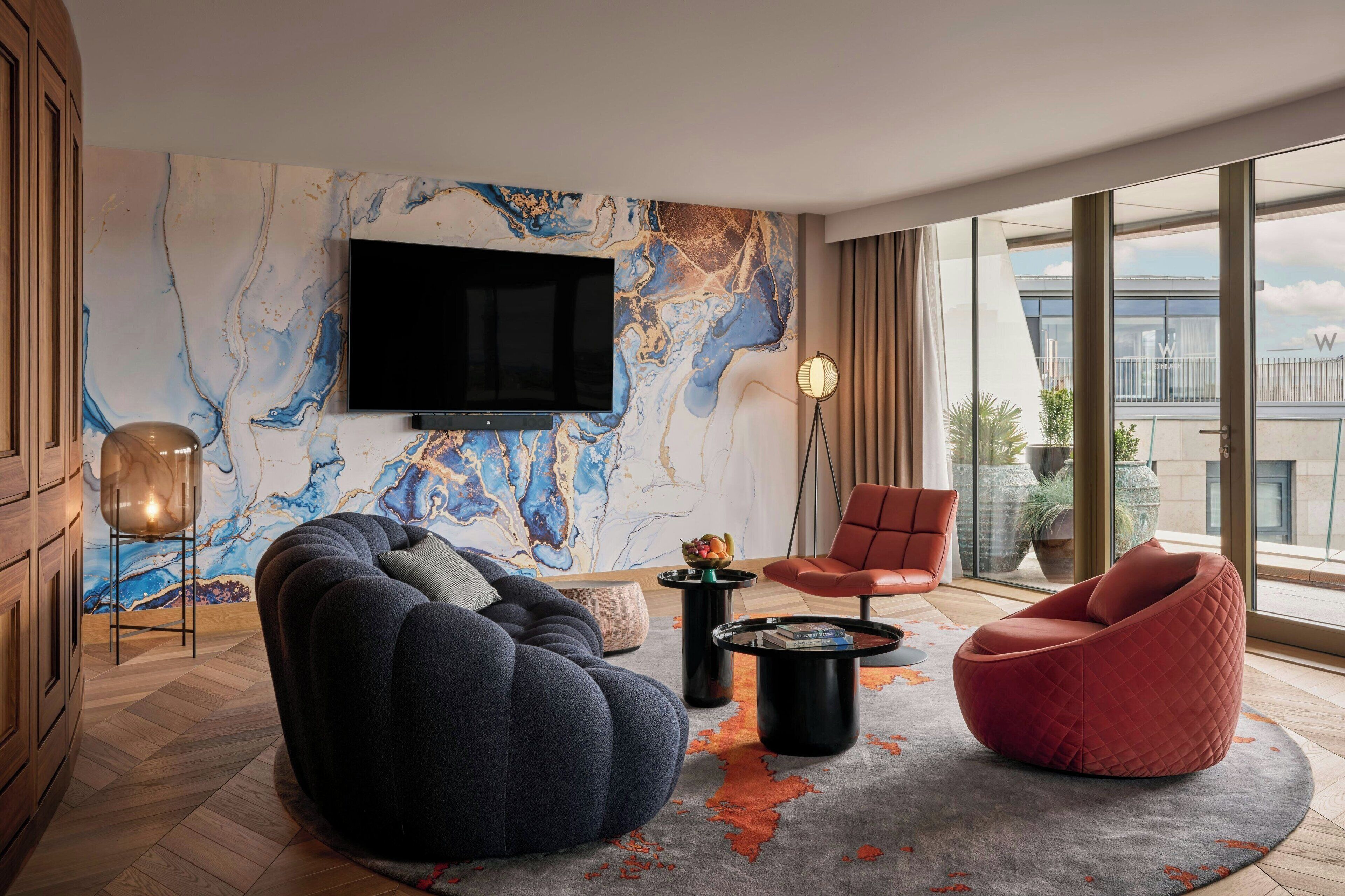 Een moderne woonkamer met een grote televisie, comfortabele zitplaatsen en uitzicht op de stad.