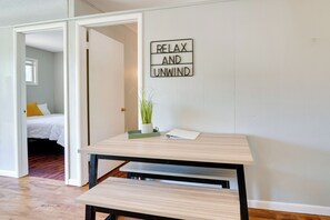 Une pièce avec un lit, une table sur laquelle se trouve un plateau et une plante, et un mur orné d’une pancarte indiquant « DÉTENTE ET RELAXATION ».