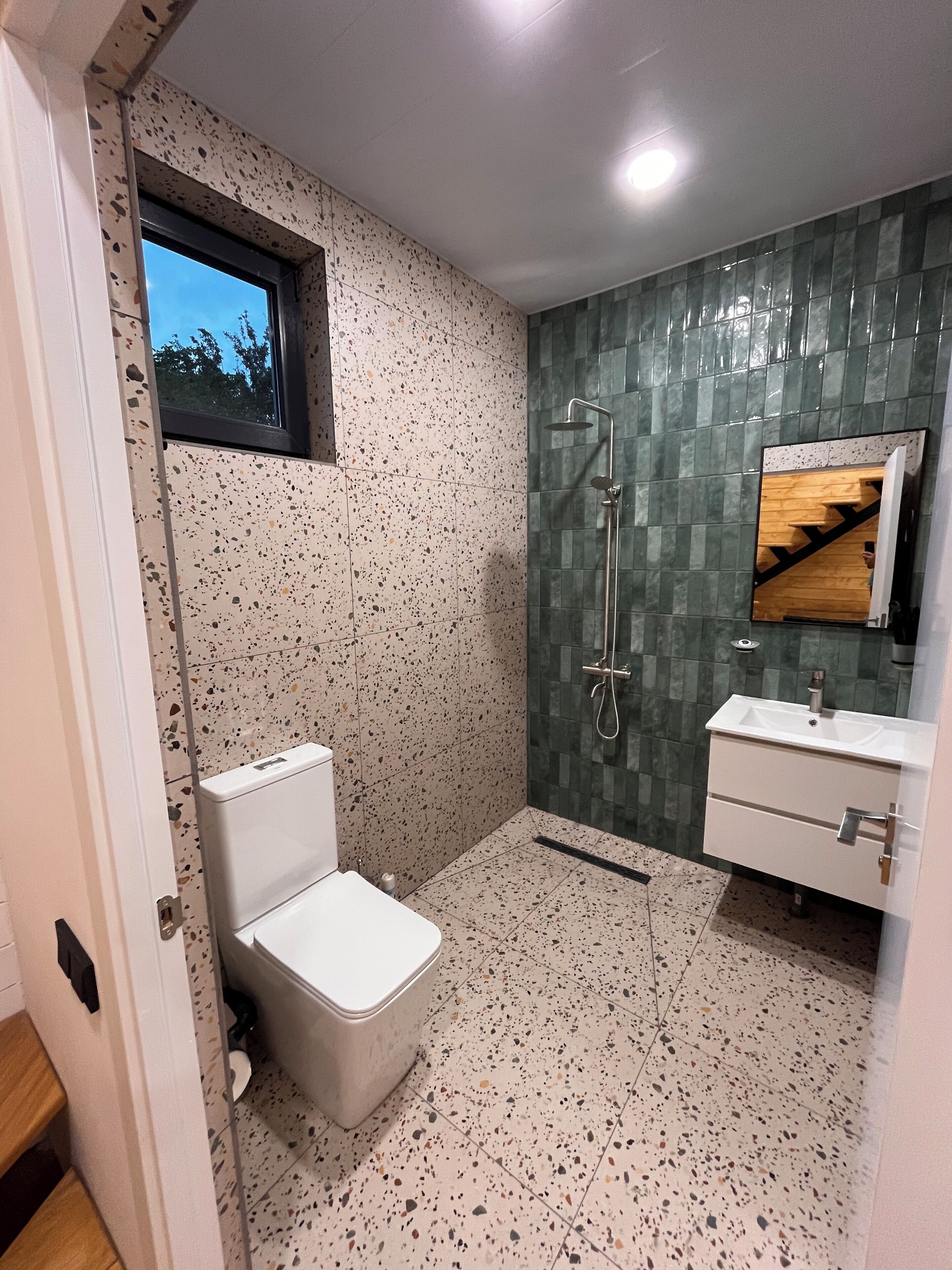 Un baño con inodoro, ducha y lavamanos.