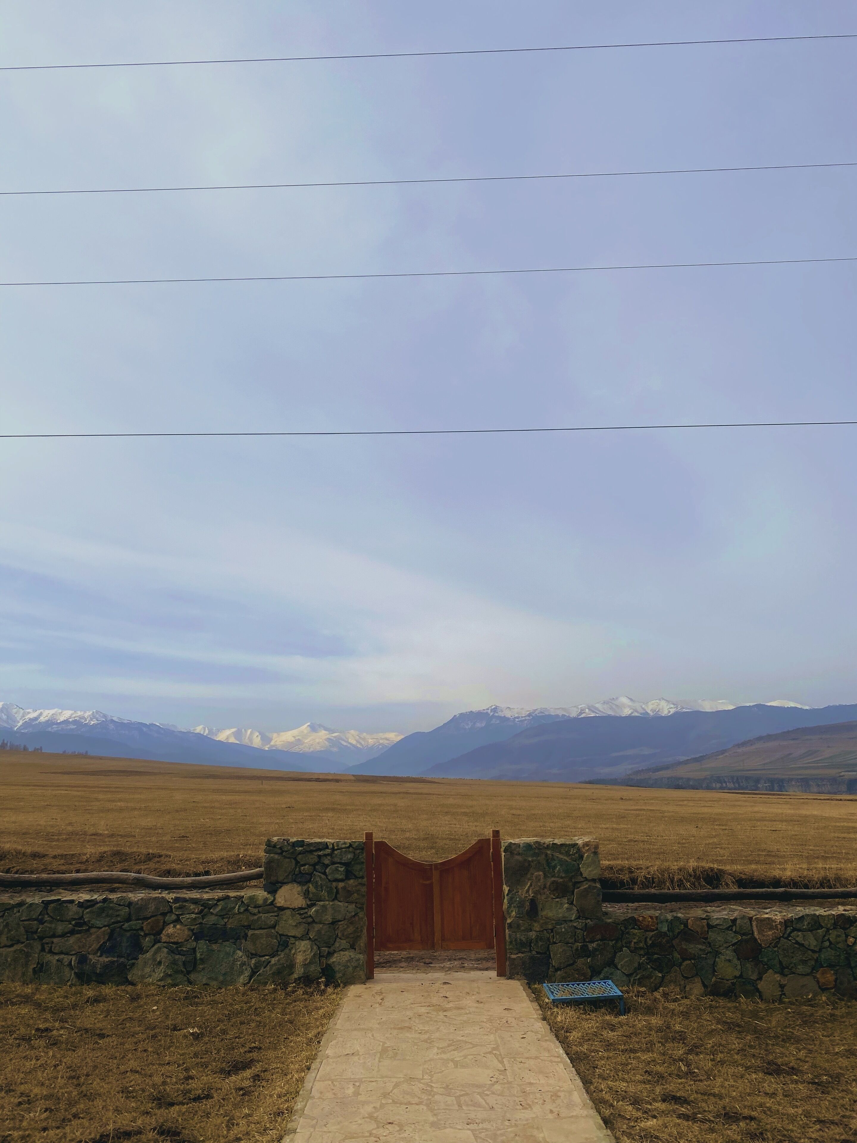 A stone wall with a wooden gate leading to a pathway.