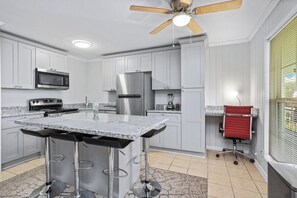 A kitchen with a central island, stainless steel appliances, and a ceiling fan. - Rest Nest Lounge Cozy Spot for Fun and Calm - HAR3 (Iowa)