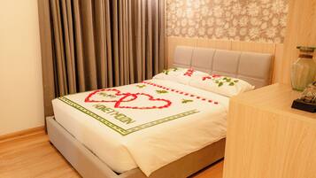Una cama con colcha floral y una decoración en forma de corazón que dice "HONEYMOON".