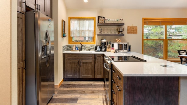 A modern kitchen with a large island, stainless steel appliances, and wooden cabinetry. - Walk to the Lifts/Private Garage/Hot Tub Access/Custom Kitchen (Keystone)