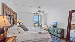 A bedroom with a bed, a television, a lamp, and a view of the ocean. - Luxury, Gulf Front Siesta Towers, Pool, Walk to Village (Siesta Key)