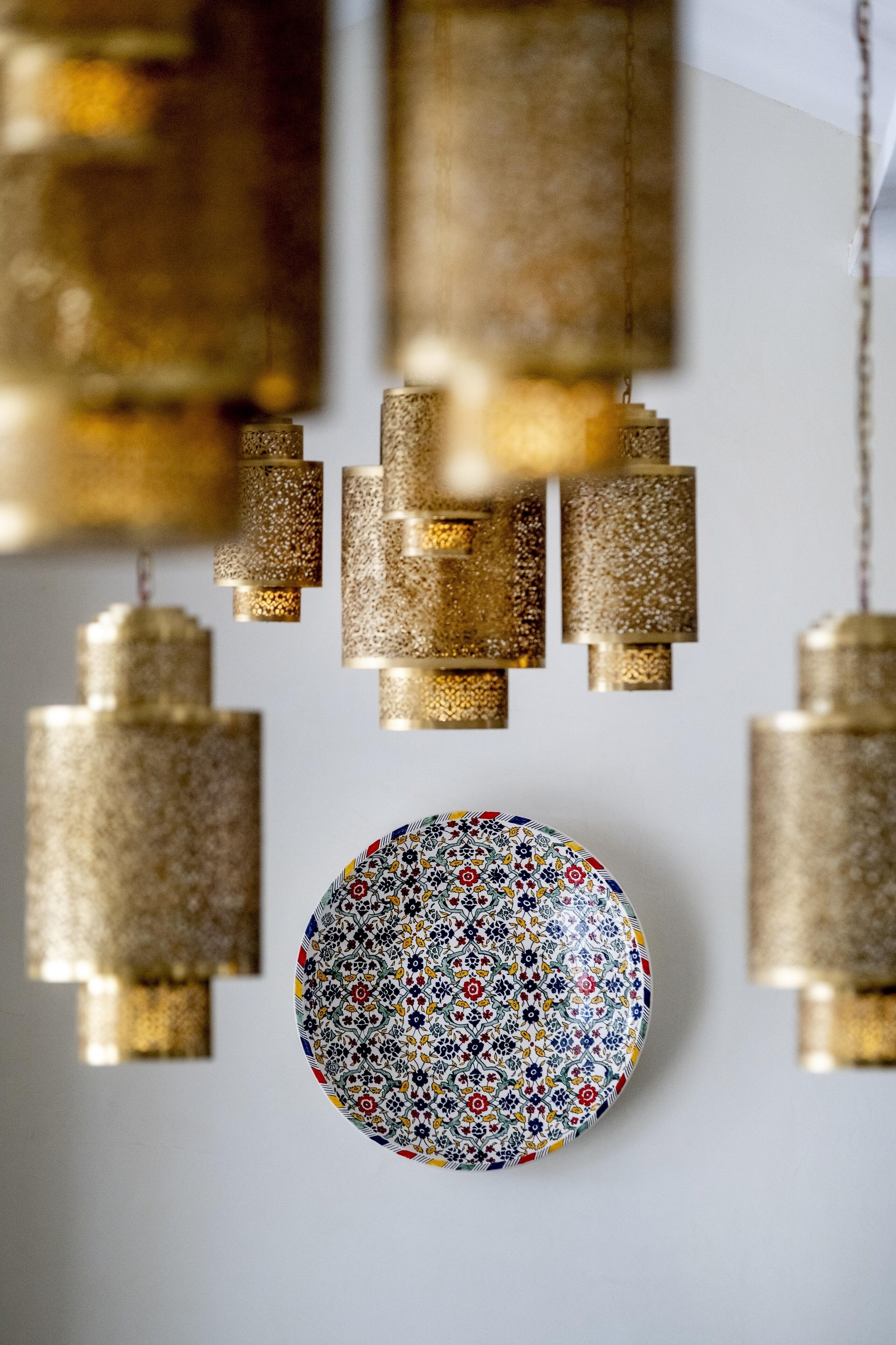Une assiette décorative ornée d’un motif floral, accrochée à un mur.
