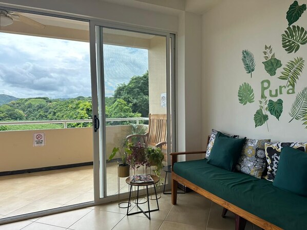 A balcony with a sofa, a chair, and potted plants. - Condo Marimba, near Sámara and Carrillo beach (Sámara)
