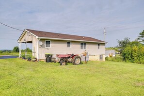 A single-story house with a garage, a red tractor, and a satellite dish. - Relax Fireside! Home < 1 Mi to Tryon International (Mill Spring)