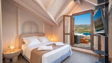 A bedroom with a bed, bedside table, and a view of a mountainous landscape through a glass door.