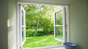 Una habitación con ventana que da a un jardín.