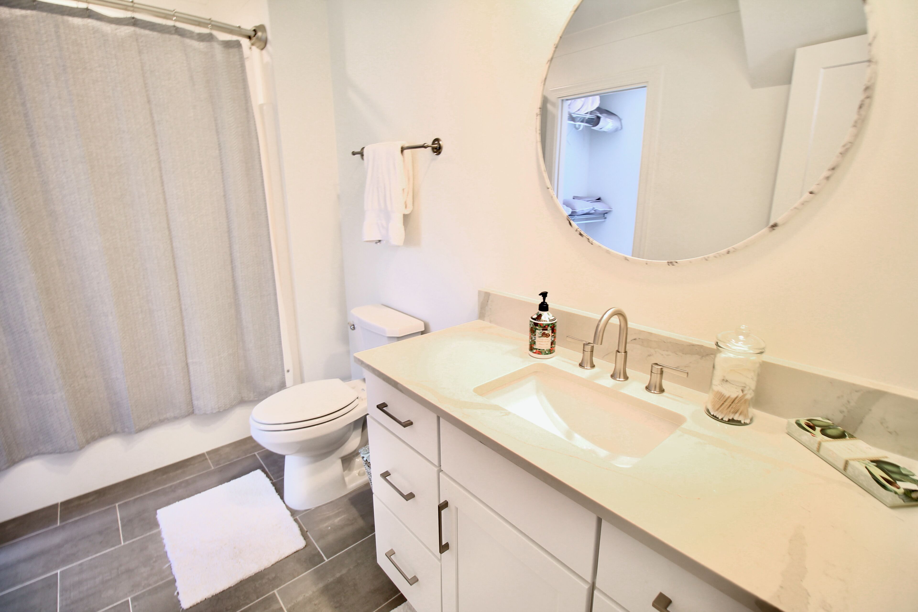 Un baño con lavamanos, tocador y retrete blancos.
